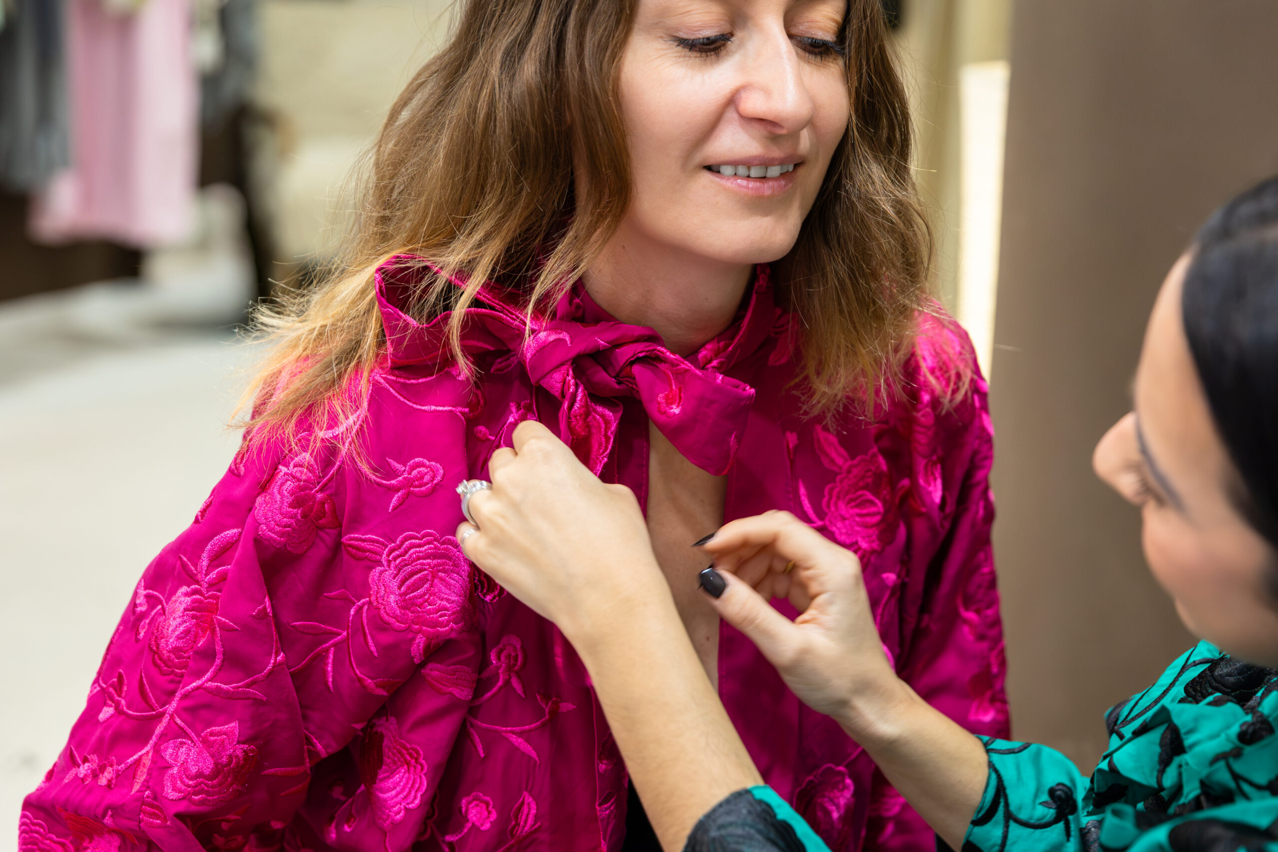 Carmen tying the bow of an embroidered pink Lorna Earth jacket